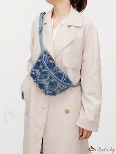 a woman in a trench coat holding a blue purse