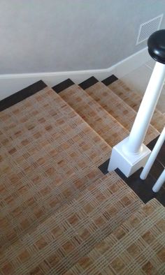 two stools sitting on top of a carpeted floor next to a stair case