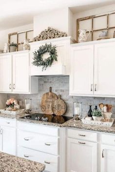 a kitchen with white cabinets and granite counter tops