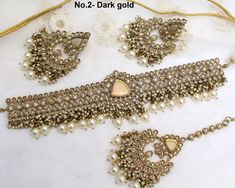 *Light weight gold choker necklace Set with earrings Tikka as shown in the pic.  * Studded with crystals and rhinestones.  * One of a Kind. No.1- *Necklace Width- 1.1 inches(included drops) * Earrings Length: 2.4 inches(included drops) *Earrings width- 1.1 inches No.2- *Necklace Width- 1.6 inches(included drops) * Earrings Length: 2.9 inches(included drops) *Earrings width- 1.6 inches No.4- *Necklace Width- 1.6 inches(included drops) * Earrings Length: 2.9 inches(included drops) *Earrings width- Gold Necklaces With Stone Work For Party, Gold Jewelry Sets With Stone Work For Party, Gold Bridal Choker Necklace For Party, Gold Choker Jewelry Sets For Celebration, Gold Choker With Stone Work, Gold Kundan Jewelry For Party, Heavy Gold Jewelry Sets For Party, Heavy Gold Bridal Necklace For Party, Gold Choker Jewelry With Stone Work