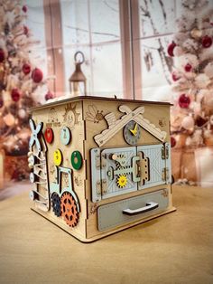 a wooden box that is sitting on a table next to a christmas tree with decorations