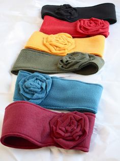 four different colored headbands with flowers on them sitting on top of a bed