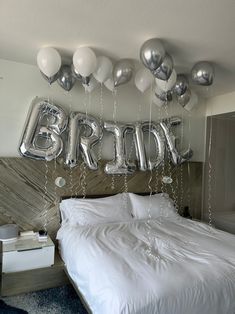 a bedroom decorated with balloons and the word bridal spelled out in silver foil letters