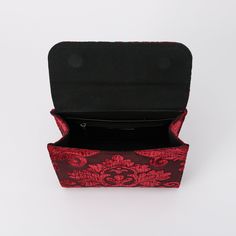 an open red and black purse on a white surface