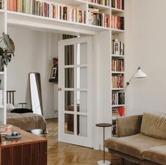 a living room filled with furniture and bookshelves full of different types of books