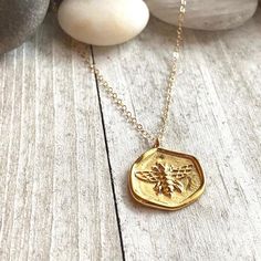 Bee Necklace, Gold Bee Necklace, Bee Pendant Necklace,Bee Coin Necklace,Bee Necklace Gold,Gold Bee Necklace, Bee Jewelry,Honey Bee Necklace A darling little necklace featuring a charming little gold honey bee.  The perfect gift for someone you love and full of special meaning. The bee, as a totem animal, are for those whose greatest wish is for all living things to co-exist in peace and harmony. In Egypt, the bee was a symbol of royalty and power. This comes from the legend that the bee was born Handmade Honey Color Jewelry Gift, Handmade Honey Jewelry For Gift, Handmade Honey-colored Jewelry For Gifts, Tiny Gold Necklace For Her, Handmade Gold Charm Necklace For Mom, Turquoise Earrings Gold, Coin Necklace Gold, Totem Animal, Raw Stone Earring