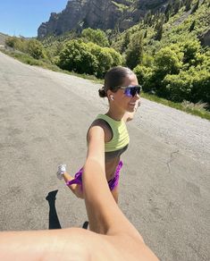 a woman is running down the road with her arm wrapped around another person's leg