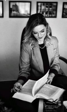 a woman sitting at a desk reading a book