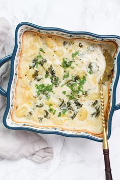 a casserole dish with spinach and cheese in it on a white table