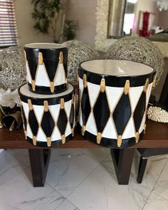 three black and white vases sitting on top of a table