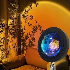 an illuminated lamp sitting on top of a couch next to a plant in a vase