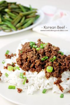 a white plate topped with rice and ground beef next to green bean sprouts