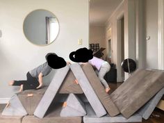 two people are playing in the middle of a living room with furniture made out of cement blocks