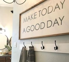 there is a sign that says make today a good day hanging on the wall next to hooks