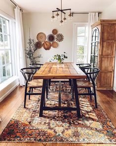 a wooden table sitting on top of a rug in a living room next to a window