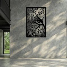 an abstract painting hangs on the wall above a concrete floor in front of a large window