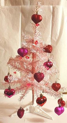 a white christmas tree with red and pink ornaments