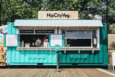 a blue food truck parked on top of a wooden deck