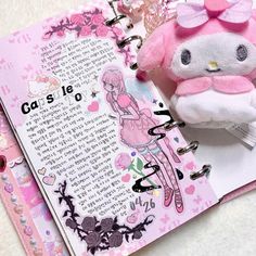 a hello kitty doll sitting on top of an open book next to a stuffed animal