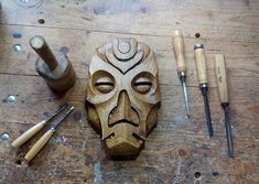 a wooden mask sitting on top of a table next to tools