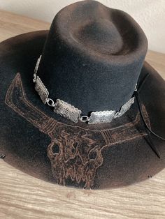 *Size: Medium 6 3/4 - 6 7/8 *Black felt Charlie1horse Highway style hat *Burned & distressed  *Bull skull burned on the brim *Large silver concho hat band with black leather ties Western Hat With Flat Crown For Festivals, Western Style Hat With Flat Crown For Festivals, Rustic Felt Hat For Rodeo With Flat Crown, Western Silver Hat With Short Brim, Rustic Flat Crown Felt Hat For Rodeo, Vintage Flat Crown Hat Bands For Festivals, Western Hat With Concho And Flat Brim, Curved Brim Concho Hat Bands For Rodeo, Flat Brim Concho Hat For Rodeo