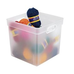 a plastic container with yarn and balls of yarn in it, on a white background