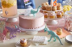 a table topped with cakes and cupcakes covered in frosting