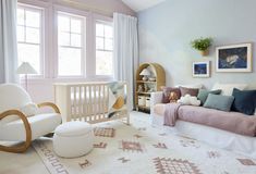 a baby's room with a crib, chair and rug