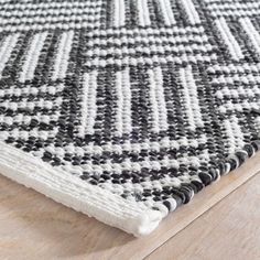 a black and white rug on top of a wooden floor