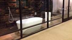 a bath tub sitting inside of a bathroom next to a shower stall with glass doors