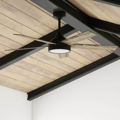 a ceiling fan mounted to the side of a wooden ceiling in a room with white walls