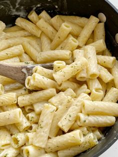 a wooden spoon is in a pot full of pasta