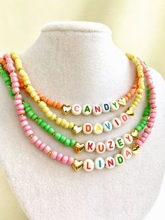 "Welcome to our vibrant and joyful personalized name necklace collection! Our colorful necklaces are perfect for children and make for a wonderful kids' birthday gift, designed to bring smiles to their faces. With six stunning color options to choose from, each necklace is a unique masterpiece. Crafted with colorful beads and adorned with Mother of Pearl letters that spell out a custom name, these necklaces are truly one of a kind. Make your little one's day special by gifting them a personalized name necklace that reflects their unique personality and style. Whether it's for a birthday, a special occasion, or just to show your love, these necklaces are sure to be cherished keepsakes.\" HOW TO ORDER ? 1- Choose the letter quantity of the name/word/phrase/initials you want. 2- Find the righ Trendy Personalized Necklaces For Personalized Gifts, Trendy Personalized Necklaces For Gifts, Trendy Personalized Necklace For Personalized Gift, Trendy Personalized Charm Necklace For Mother's Day, Trendy Personalized Charm Necklace Gift, Cute Personalized Multicolor Charm Necklaces, Trendy Personalized Adjustable Charm Necklaces, Trendy Adjustable Personalized Charm Necklaces, Adjustable Multicolor Charm Necklace For Birthday