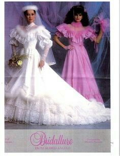 two barbie dolls dressed in wedding dresses and veils, one is wearing a white dress