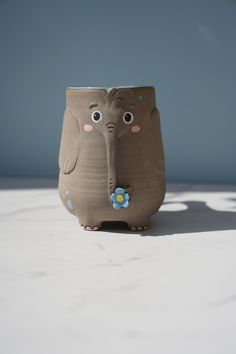 an elephant shaped vase sitting on top of a table