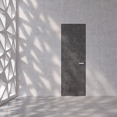 an open door in a white room with concrete walls and shadows on the wall behind it