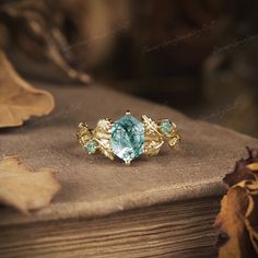 a close up of a ring on top of a wooden table with leaves around it