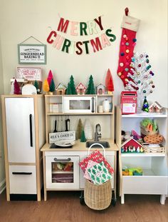 a play kitchen with christmas decorations on the wall