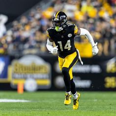 a football player running with the ball in his hand and people watching from the stands