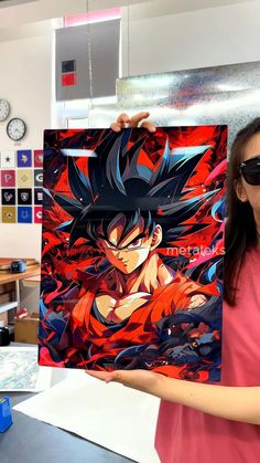 a woman holding up a dragon ball painting