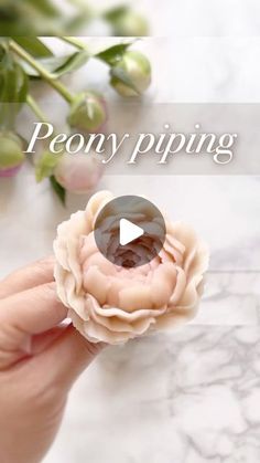 a person holding a flower with the words peony piping in front of it