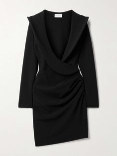 a black dress with an asymmetric twist on the front and back, is shown