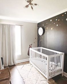 a baby's room decorated in black and white with stars on the wall, crib