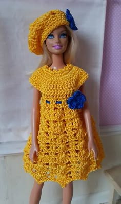 a doll wearing a yellow crocheted dress and hat