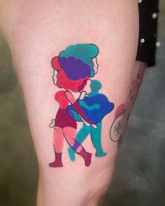 a woman's leg with a colorful tattoo design on her left thigh and the image of two people hugging each other