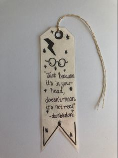 a harry potter bookmark hanging from a string on a white background with the words, just because it's in your head don't mean it's not real dumbborar