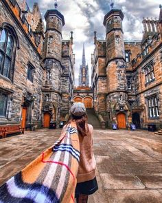 a woman standing in front of an old castle