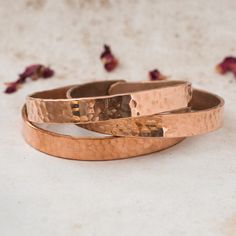 Introducing our Handmade Hammered Copper Bracelets, exquisitely crafted with love in Nepal by skilled artisans who have transformed our vision into a reality. Elevate your style with these timeless accessories that effortlessly blend the essence of hippie and boho aesthetics, meticulously created for the free-spirited souls. PRODUCT DETAILS: - Handcrafted in Nepal - Made from Pure Solid Copper - Unisex design, perfect for all - Free size and Adjustable, ensuring a comfortable fit for everyone ARTHRITIS RELIEF & ONE-OF-A-KIND APPEAL:  Not only do these bracelets add a touch of bohemian charm to your style, but they also offer potential benefits for arthritis pain. Many believe that copper has natural properties that may help alleviate discomfort, making these bracelets as functional as they Artisan Rose Gold Jewelry, Bohemian Hammered Bracelets As Gift, Artisan Hammered Bracelet Jewelry, Copper Bangle Bracelets As Gift, Elegant Copper Bracelet As A Gift, Handmade Bangle Bracelets As Gift For Her, Artisan Bangle Bracelets For Weddings, Artisan Hammered Bracelet, Hand Forged Bangle Bracelets As Gift