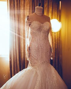 a wedding dress on display in front of a window