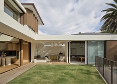 an outdoor living room and dining area with sliding glass doors on the side of the house